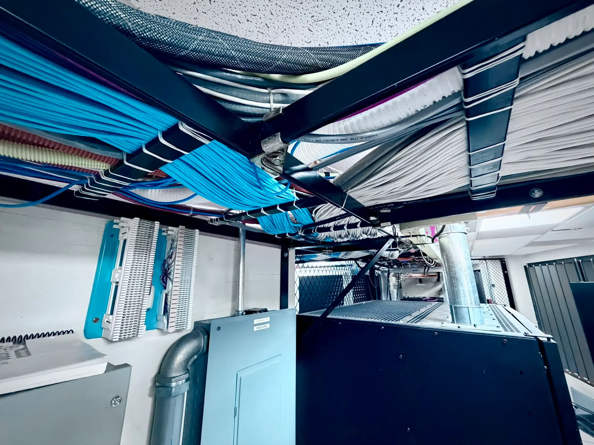 Overhead fiber trays above the cabinet rows