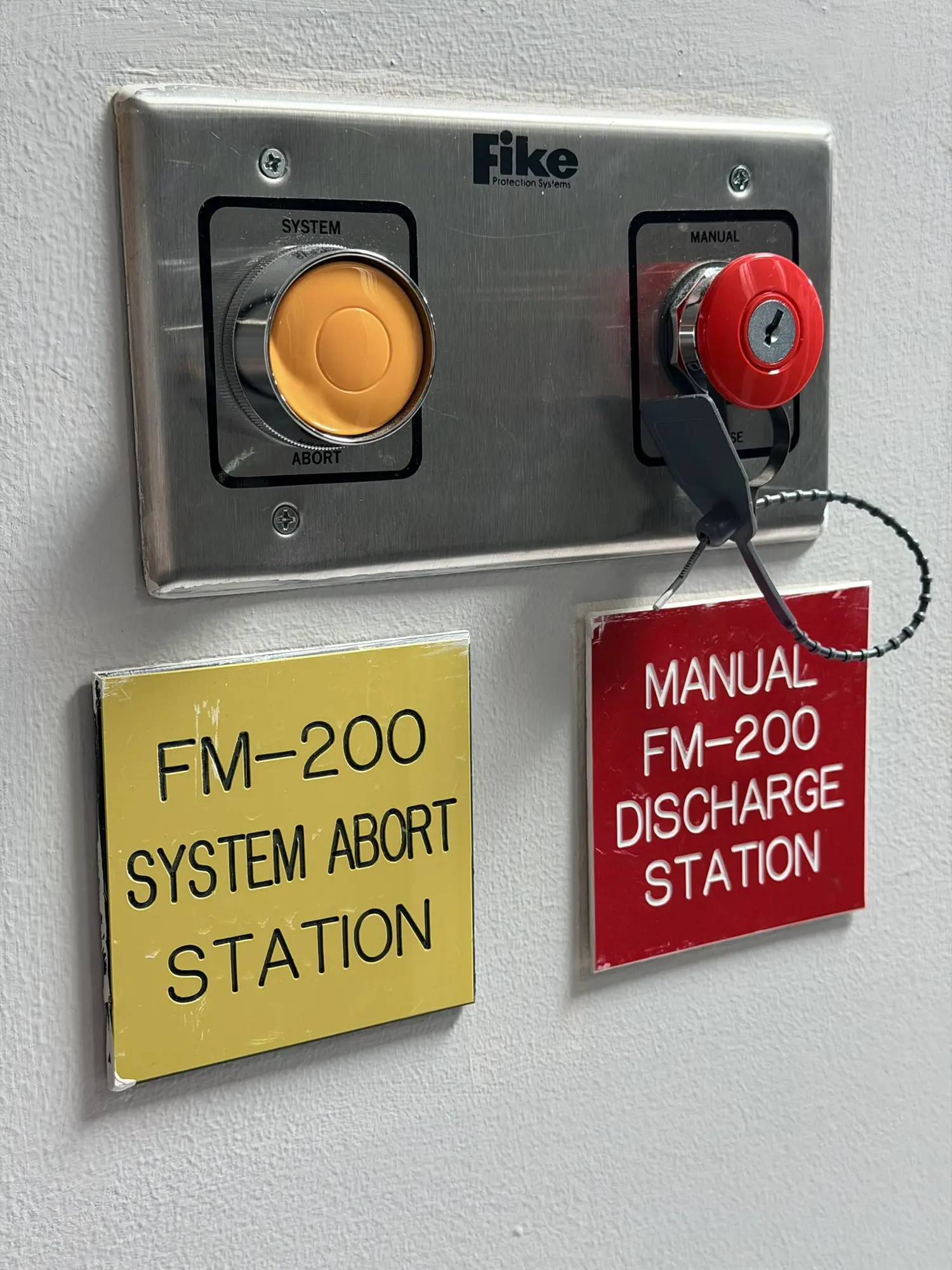 FM-200 manual discharge and system abort stations beside the cabinet rows